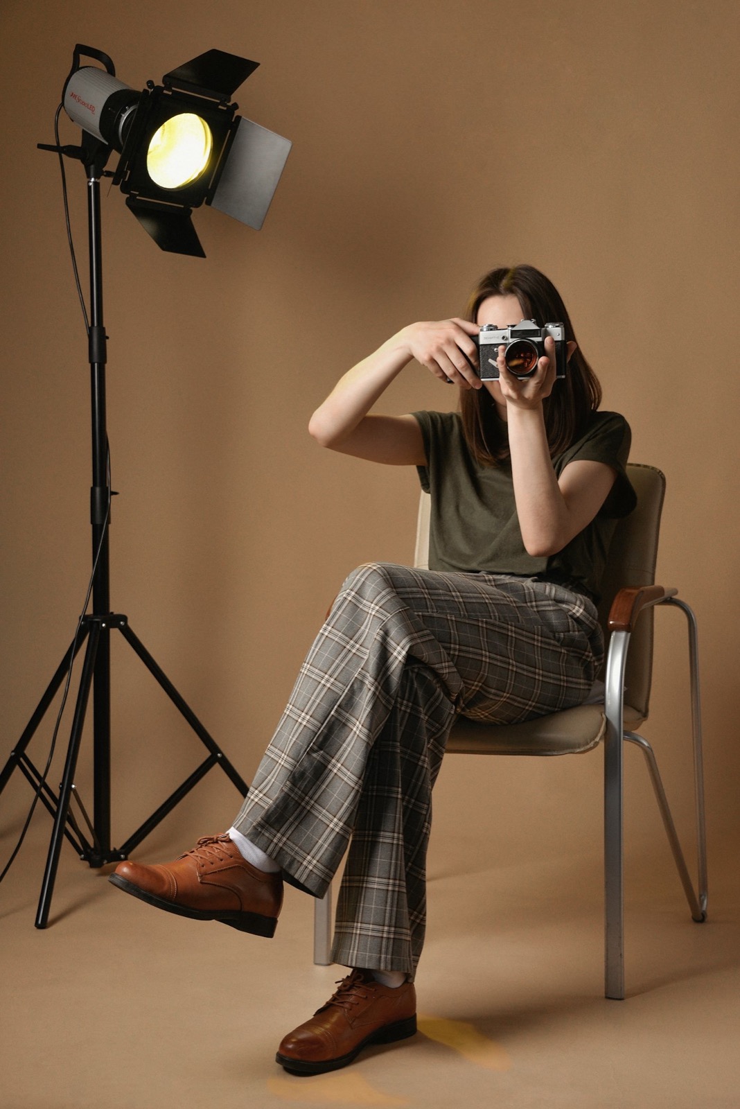 Jana Petrović sedi na stolici u studiju i fotografiše, pored nje studijsko svetlo