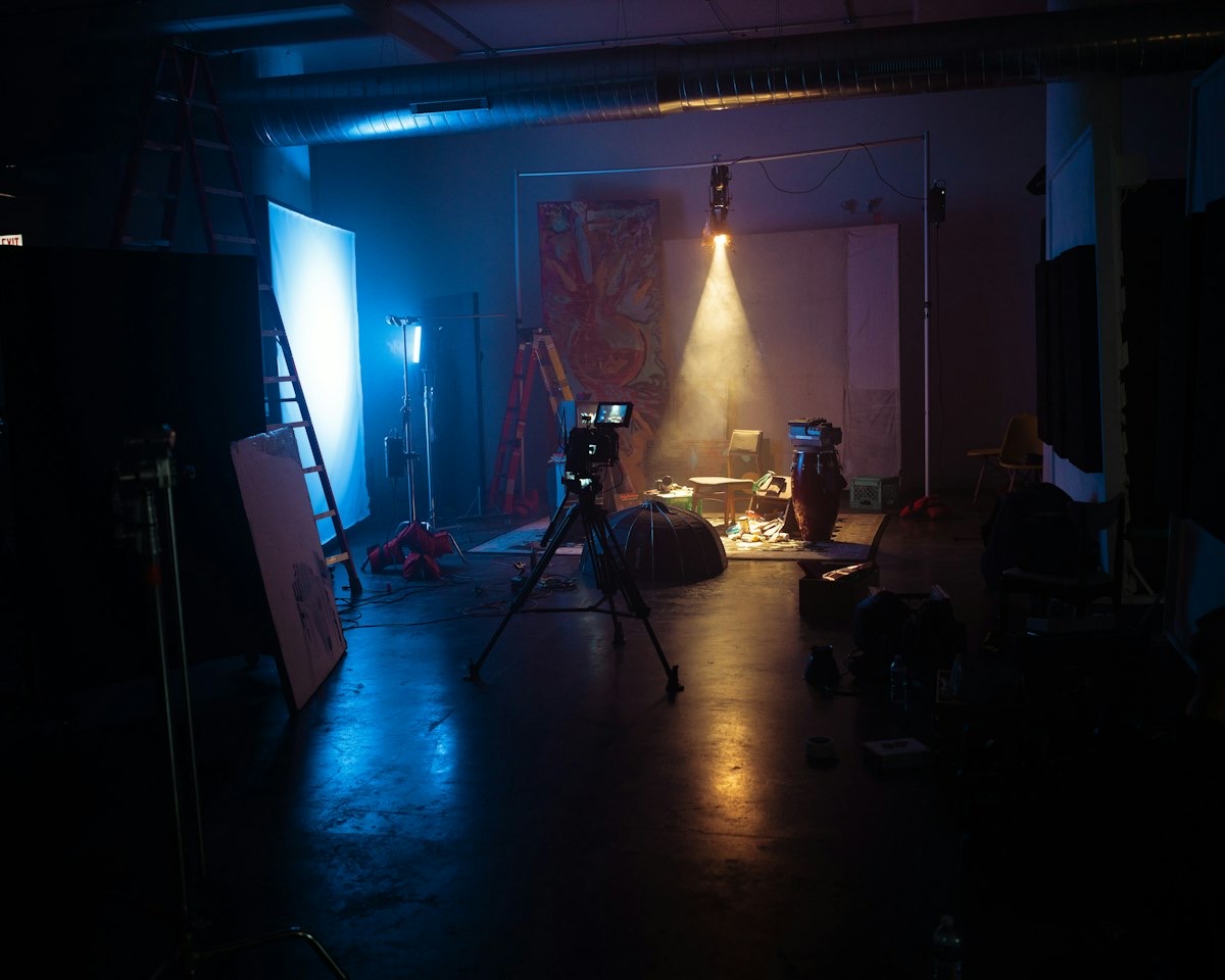 Zamračen studio sa fotoaparatom na stativu i postavljenom rasvetom