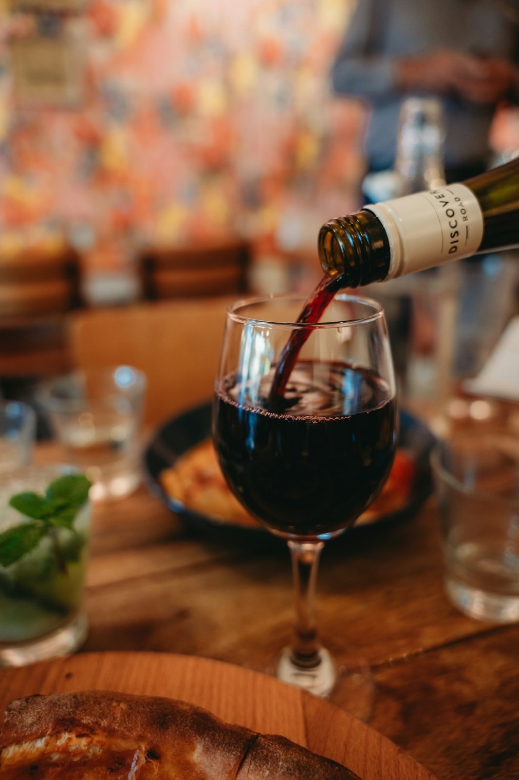Crveno vino se sipa u čašu za stolom